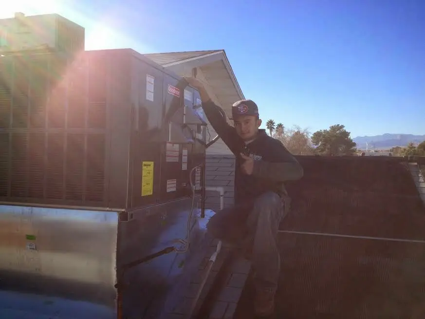 HVAC technician performing Heat Pump Repair on a rooftop unit in Gunbarrel