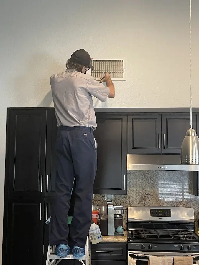 Technician inspecting an air vent during HVAC service in Gunbarrel